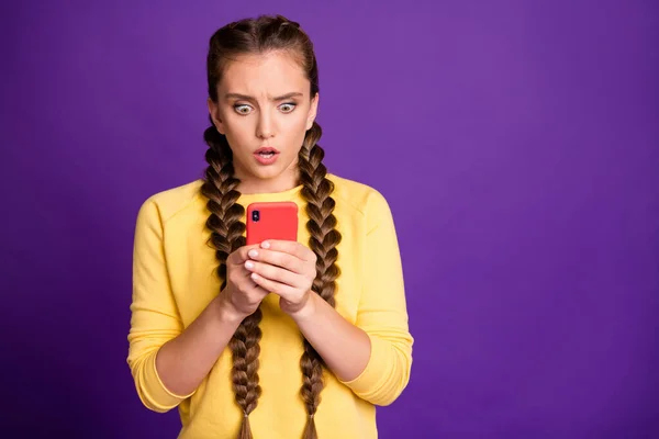 Фото дивовижної дами довгі коси, що тримають телефон, читаючи жахливі новини безмовний стартап блог епічний провал носіння випадковий жовтий пуловер ізольований фіолетовий кольоровий фон — стокове фото