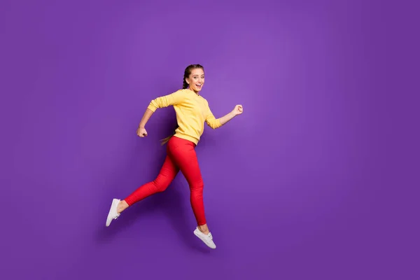 Foto de perfil de cuerpo completo de la señora milenaria saltando alto apresuramiento venta compras velocidad carrera correr desgaste casual amarillo jersey pantalones rojos aislados color púrpura fondo —  Fotos de Stock