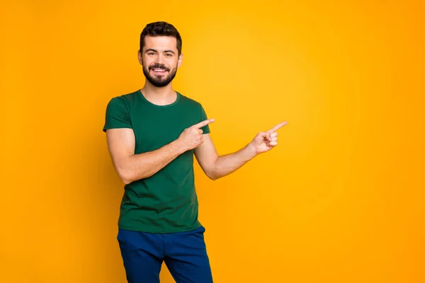 Retrato de cara alegre positiva legal promotor ponto indicador espaço cópia comentário anúncios sugerem selecionar promoção desgaste roupa boa aparência isolado sobre cor amarela fundo — Fotografia de Stock