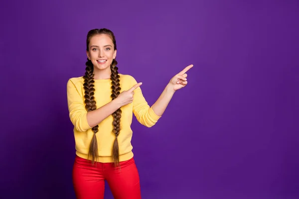 Photo of amazing lady hosszú zsinór frizura jelzi ujjak üres tér tanácsadás hűvös vásárlási árak viselése alkalmi sárga pulóver piros nadrág elszigetelt lila színű háttér — Stock Fotó