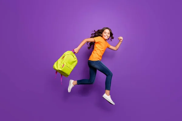 Full length body size view of nice attractive lovely cheerful wavy-haired girl jumping carrying bag running autumn fall 1 first September isolated on lilac purple violet pastel color background — стоковое фото