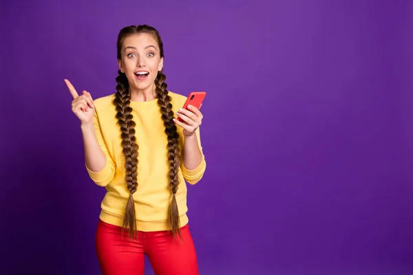 啊哈。 艾芙丽卡 令人惊奇的女士手持电话的照片为新发帖食指穿着休闲黄跳跃红裤子隔离紫色背景有创意的计划 — 图库照片