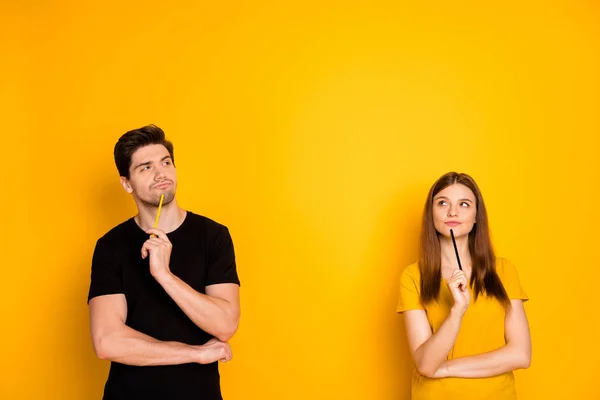 Photo of thoughtful guessing thinking couple of two people pondering over their new project being worked on by them as freelancers isolated over vivid color background in black t-shirt — Stock Photo, Image