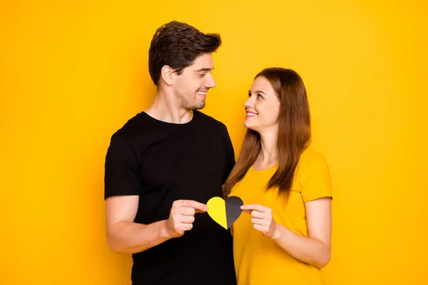 Foto de alegre linda encantadora pareja bonita de personas hermosas mirándose cariñosamente abrazando la celebración de corazón multicolor que simboliza el amor aislado color vivo fondo — Foto de Stock