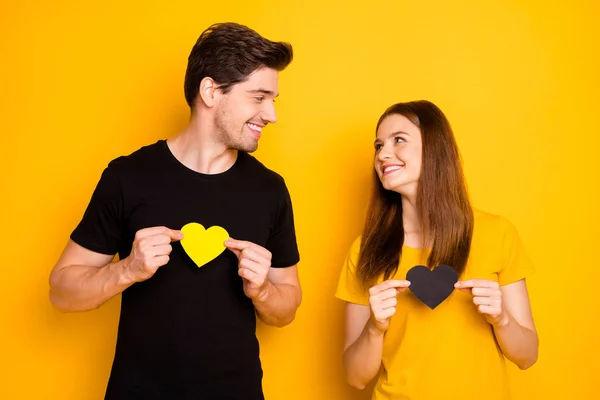 Photo of charming pretty cute nice couple girl and guy having shared their colorful hearts with each other looking into eyes in love isolated over vivid color background in black t-shirt — Stock Photo, Image