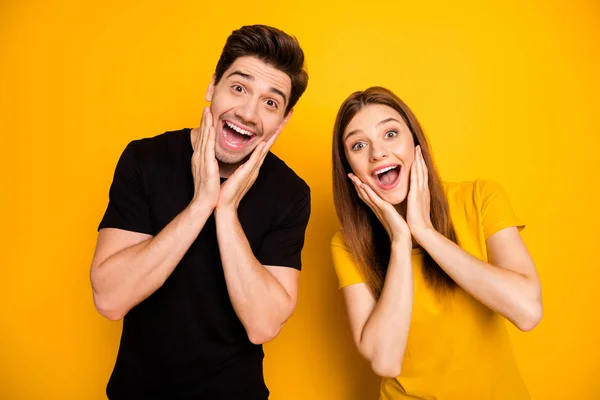 Foto de morena cabelos charmosos casal bonito bonito olhando para você com admiração extático sobre os bens com desconto expressando emoções positivas na moda preto t-shirt isolado cor viva fundo — Fotografia de Stock