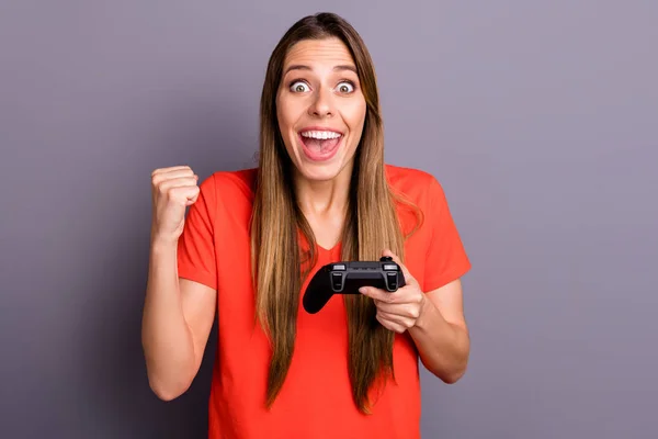 Wow omg ik win. Verbaasd onder de indruk meisje spelen video game krijgen overwinning schreeuwen verhogen vuisten dragen stijlvolle rode t-shirt geïsoleerd over grijze kleur achtergrond — Stockfoto