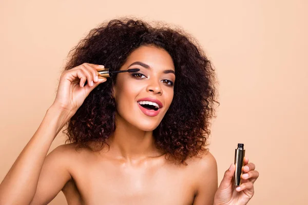 Close up foto mooi verbazingwekkend ze haar donkere huid golvend model dame handen vasthouden armen met behulp van nieuwe extra lange wimpers applicator adviseren kopen koper make-up studio naakt geïsoleerde beige pastel achtergrond — Stockfoto