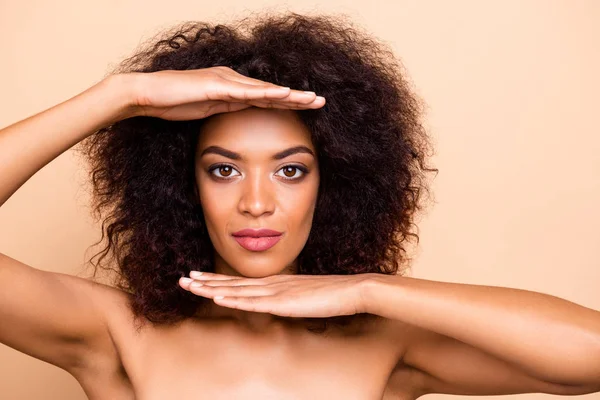 De cerca foto hermosa ella su piel oscura modelo señora morena ondulado peinado palmas por encima de la cabeza muestran crema loción acción pura máscara perfecta estética desgaste nada aislado pastel beige fondo — Foto de Stock