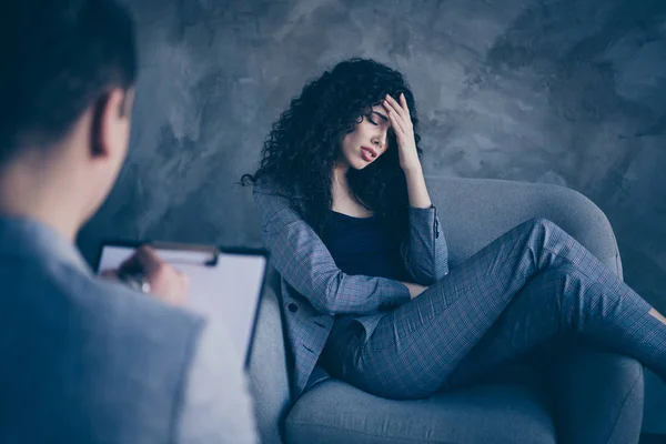 Portrait of her she nice attractive jobless disappointed dissatisfied unsatisfied wavy-haired girl sitting in chair telling doctor about fail concrete wall background work place station — Stock Photo, Image