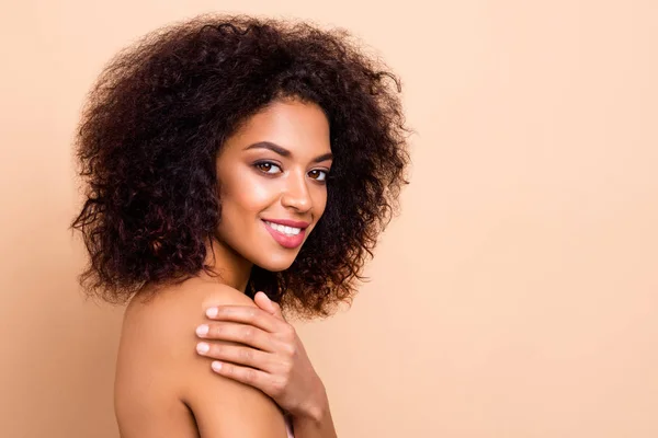 Close up zijprofiel foto mooi ze haar donkere huid model dame pluizig kapsel salon spa procedure knuffel omarmen esthetische pure zachte zijdezachte schouder dragen niets geïsoleerde pastel beige achtergrond — Stockfoto