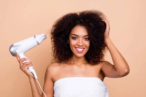 Close-up portrait of her she nice-looking attractive well-groomed cheerful cheery wavy-haired girl using electric dryer preparing for party isolated over beige pastel background — Stock Photo, Image