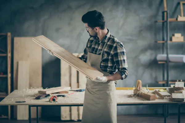 Ernsthafte zuversichtlich Arbeiter Reparatur Möbel halten Holzplan Bord Test Glättung Schnitzerei Look in Haus Garage — Stockfoto