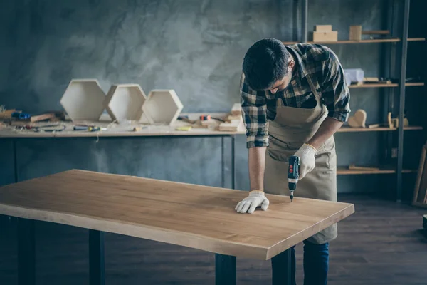 Фото красивого ретельного хлопця, який збирає стіл ручної роботи з плиткою, робить фінішні дії перед продажем власного сайту дерев'яної промисловості деревообробного магазину гараж в приміщенні — стокове фото