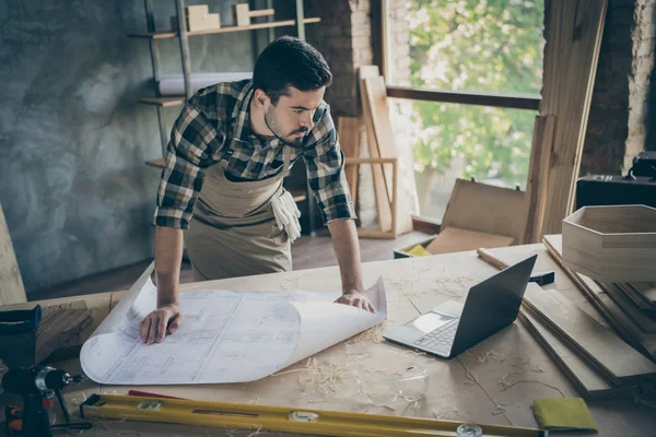 Konzentrierte Arbeiter stehen in der Nähe Tisch haben weißen Bauplan aussehen in Computeruhr-Bau-Werkstatt im Haus Haus Garage — Stockfoto