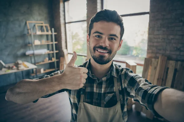 Closeup photo of handsome guy master raising thumb up making selfies in new own wooden business industry studio looking customers woodwork shop garage indoors — ストック写真