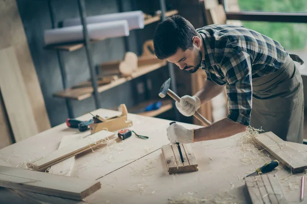 Portret van zijn hij mooie aantrekkelijke gerichte professionele man specialist creëren van start-up nieuwe moderne huis decoratieve inrichting ding orde met behulp van hamer op moderne industriële loft stijl interieur — Stockfoto