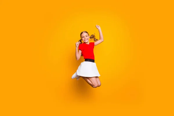 Полная длина фото красивой маленькой леди довольно длинные хвосты прыжки высокий удивительный хорошее настроение радуясь выходным носить повседневные красное белое платье изолированный желтый цвет фона — стоковое фото