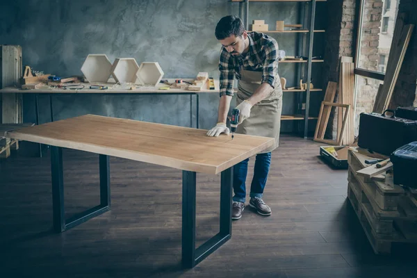 Full body photo of handsome careful guy assembling handmade slab table making finish actions before selling website own wooden business industry woodwork shop garage indoors — Stock Photo, Image
