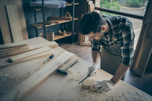 Photo of concentrated man processing wooden heart with chisel polishing in gloves working with building tools — Stock Photo, Image