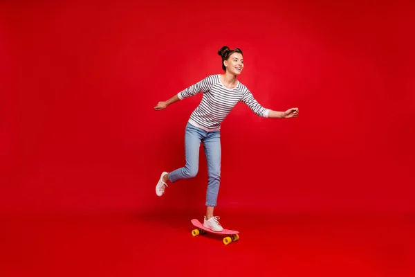 Foto lateral de perfil de longitud completa de paseo de chica alegre positivo tiene paseo libre de otoño su skate usar zapatillas de deporte de traje blanco aisladas sobre fondo de color rojo — Foto de Stock