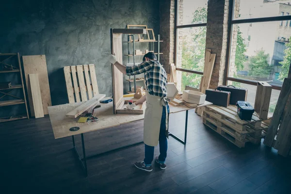 后背全长照片集中工人手工艺者更新板桌在家居车库用钻头固定木工活 — 图库照片