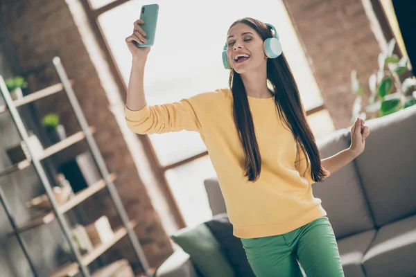 Rolig funky glad flicka vill lyssna musik använda smartphone hitta melodi har blå trådlöst headset njuta sjunga dans i lägenhet inomhus — Stockfoto