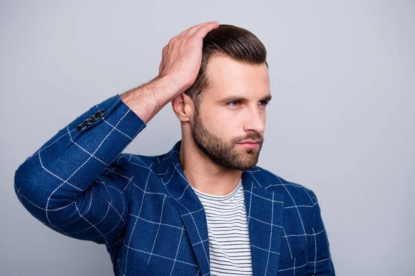 Foto de cerca de un hombre serio y confiado que aplica bálsamo en su cabello para lucir mejor con cerdas en el fondo de color gris aislado de la cara sin afeitar — Foto de Stock