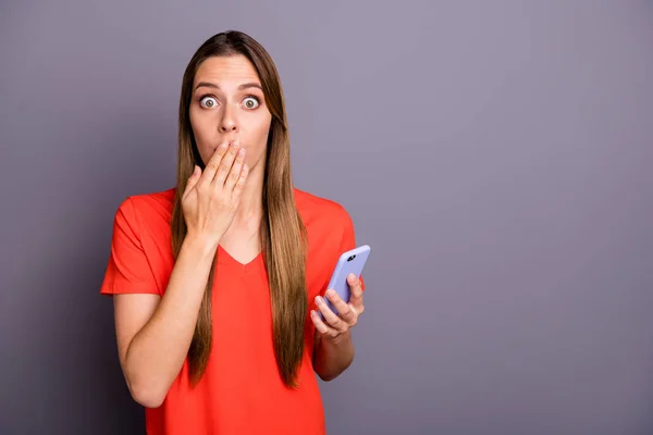 Negatif şok kız blogger sosyal medya kullanıcısı portresi cep telefonu kullan özel bilgileri paylaş yakından kendini suçlu hisset palmiyesi turuncu tişört giy izole edilmiş kırmızı arka plan — Stok fotoğraf