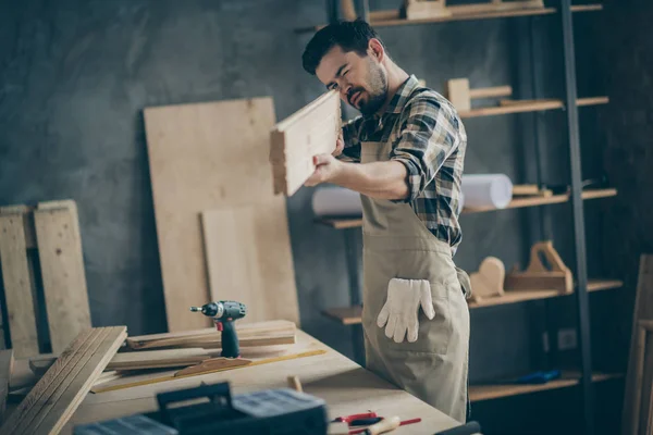 Retrato de su agradable atractivo enfocado chico trabajador calificado buscando la medición de tablón de tablero liso en el hogar moderno loft industrial interior de ladrillo de estilo interior — Foto de Stock