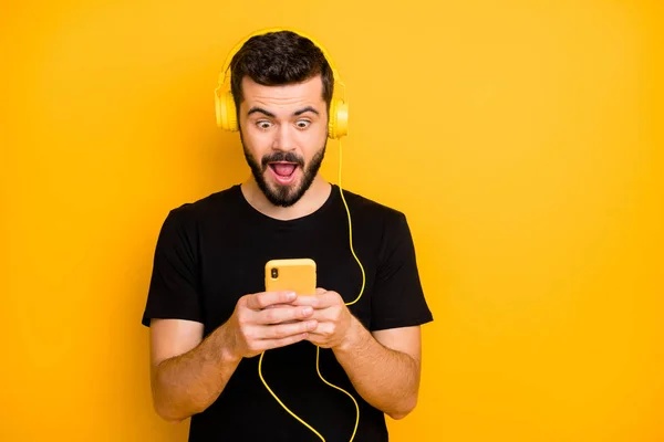 Omg Super-Hit. erstaunt überrascht Kerl Musik hören verwenden Headset-Suche Soundtrack auf seinem Smartphone finden unglaublichen Song schreien tragen gut aussehendes Outfit isoliert über gelbem Hintergrund — Stockfoto