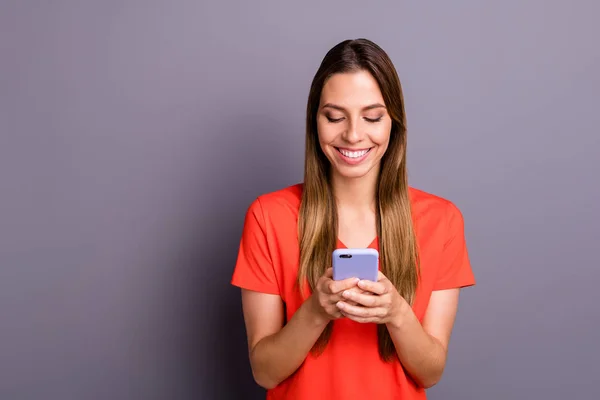 Retrato de menina alegre usar seu smartphone siga blogueiros conversando com amigos usam roupas de estilo casual isolado sobre fundo de cor cinza — Fotografia de Stock