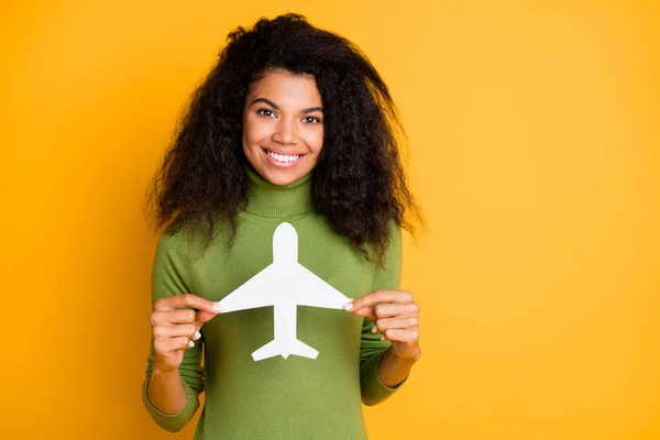 Foto de alegre positivo de raza mixta dentadura radiante linda novia demostrando juguete de avión de aire que le prepara para utilizar el servicio de sus líneas aéreas aisladas vibrante color fondo — Foto de Stock