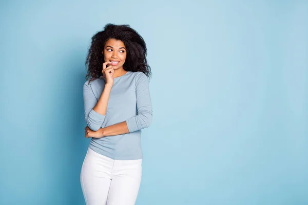 Photo of cheerful cute nice pretty girl biting nails looking into empty space planning her cunning idea in white pants trousers isolated pastel color background — Stock Photo, Image