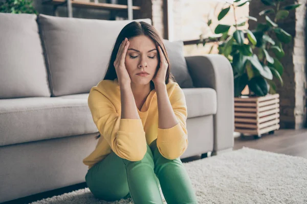 좌절 한 아픈 소녀 가 바닥에 앉아 있는 사진을 가까이 서 보면 편두통으로 고생하고 있습니다. 집 거실에서는 건강 문제가 있습니다. — 스톡 사진