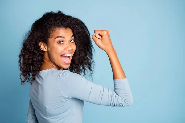 Side profil foto av glada glada söt trevlig ganska flickaktig feminin ung visar styrka i hennes muskler efter år av träning isolerad blå pastell färg bakgrund — Stockfoto