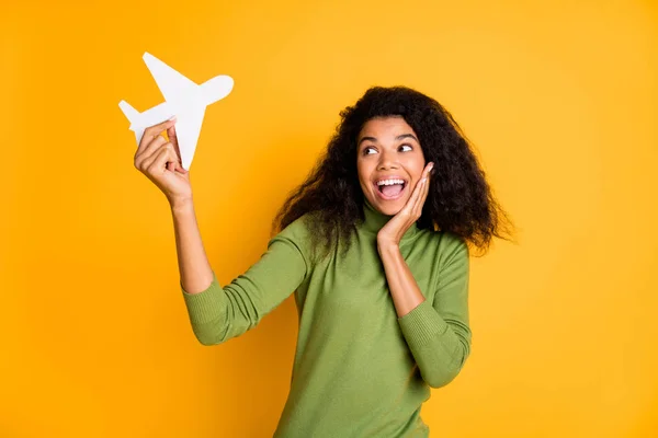 Foto van casual mixed-race positieve mooie vriendin glimlachen tandachtig vliegtuig met de hand uiten van positieve emoties wachten op reis geïsoleerde levendige gele kleur achtergrond — Stockfoto