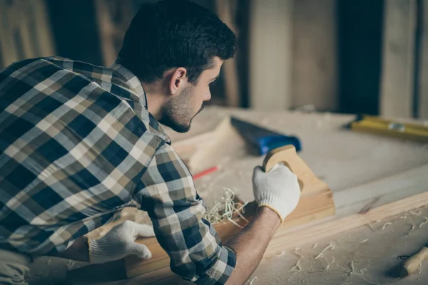 Boven hoge hoek uitzicht foto van geconcentreerde ambachtsman werk aan garage reparatie oud houten meubelen gebruik plank dragen handschoenen geruite shirt in huis garage werkplek — Stockfoto