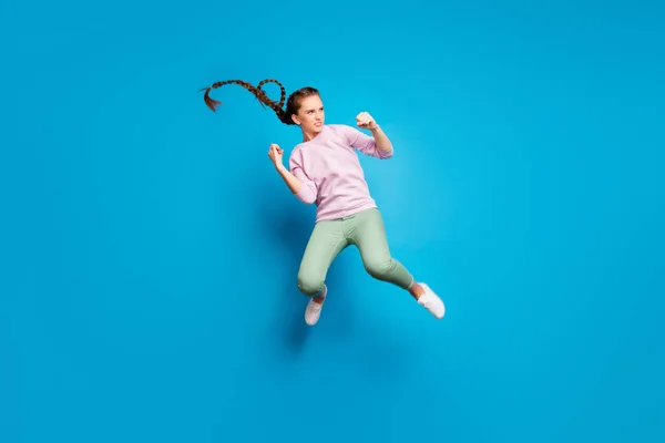 원문 기사보기 심각 한 어린 소녀가 싸움을 벌이고 있는 점프 점프하는 다리 주먹을 가진 사진 전체가 컬러 배경 위에 고립된 분홍색 분홍 스웨터를 입고 싶어 한다 — 스톡 사진