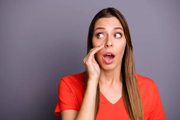 Foto av galen rolig dam hålla hand nära munnen dela färska rykten med vänner pratkvarn dålig person bära casual orange t-shirt isolerad grå färg bakgrund — Stockfoto