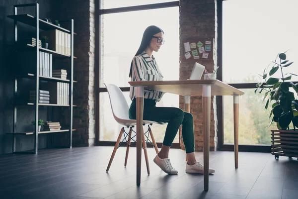 Dimensione del corpo a tutta lunghezza bassa sotto l'angolo vista foto di intelligente ragazza concetrata che lavora alla start-up prima del computer portatile in luce proveniente dalla finestra — Foto Stock