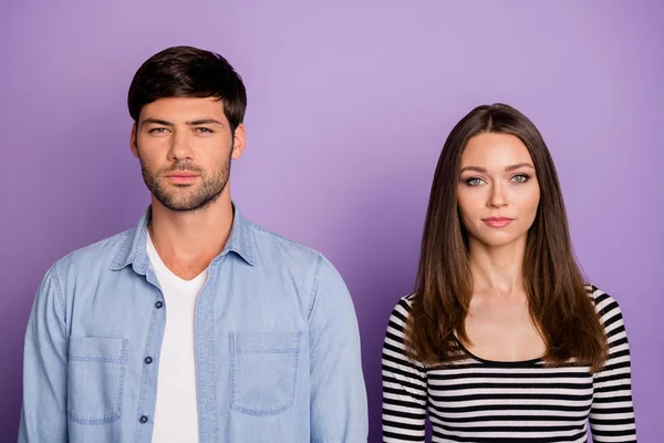 Photo of two funny people couple not smiling looking seriously on camera not talk to each other wear stylish casual outfit isolated pastel purple color background — 스톡 사진