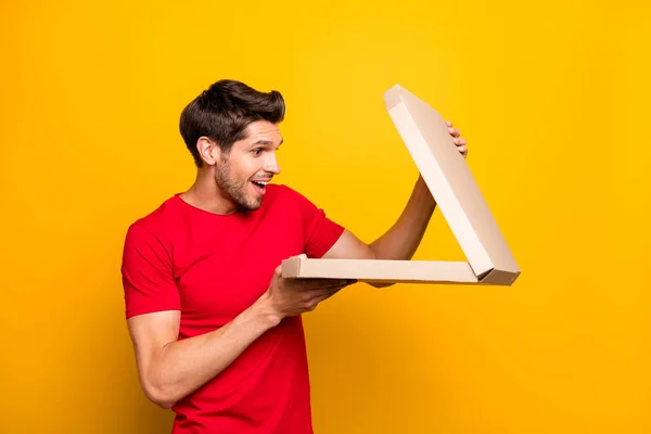 Porträtt av förvånad galen kille hålla pizza box öppen kan inte tro skrika wow omg slitage casual stil outfit isolerad över gul färg bakgrund — Stockfoto