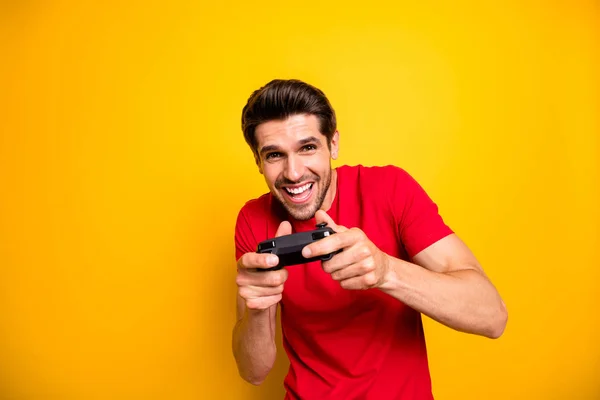 Portret van vrolijke jongen videospelletjes spelen gebruik joystick wilt winnen winnaar in snelheid race dragen stijlvolle kleding geïsoleerd over gele kleur achtergrond — Stockfoto