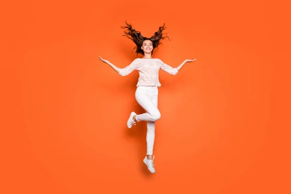 Foto de tamaño completo de alegre chica positiva sueño de ensueño de la mano muestran su ondulado corte de pelo de lujo salto de desgaste de encaje de punto conjunto zapatillas aisladas sobre fondo de color naranja — Foto de Stock