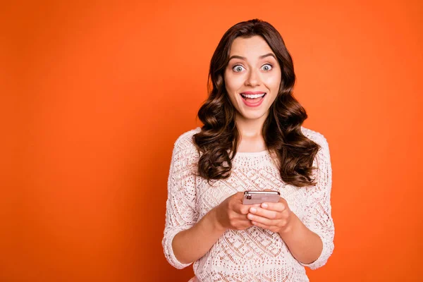 신나는 귀여운 소녀 블로거가 스마트폰으로 소셜 네트워크알림을 받는 사진은 밝은 색 배경 위로 분리 된 뜨개 질 블라우스를 입는다. — 스톡 사진