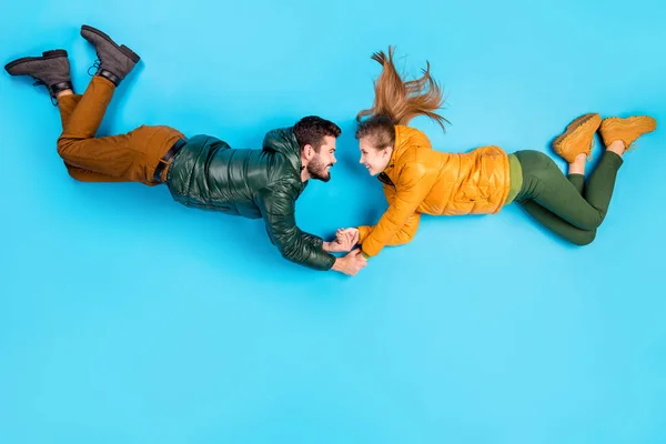 Dessus au-dessus de vue grand angle pleine longueur taille du corps photo de joyeux couple positif tombant couché tenant les mains souriantes arrière-plan de couleur bleu pastel isolé — Photo