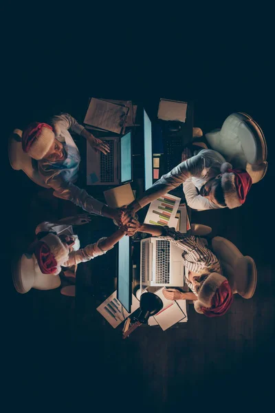 Top vertical au-dessus de la vue en angle élevé de quatre personnes coworking serrant la main passer Eve Noel Décembre jour de vacances week-end culture d'entreprise au poste de travail tard dans la nuit — Photo