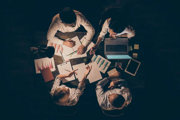 Topo acima vista de alto ângulo de quatro empresários trabalhadores parceiros líderes cooperando elaboração de relatório de estratégia analisando a pesquisa no final da noite posto de trabalho — Fotografia de Stock