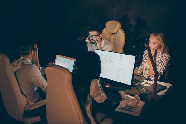Zdjęcie czterech partnerów biznesowych siedzących krzesła stół pracujący razem do późna pracoholicy przytłoczone trudne zadania problematyczne formalwear lampa światło wewnątrz — Zdjęcie stockowe
